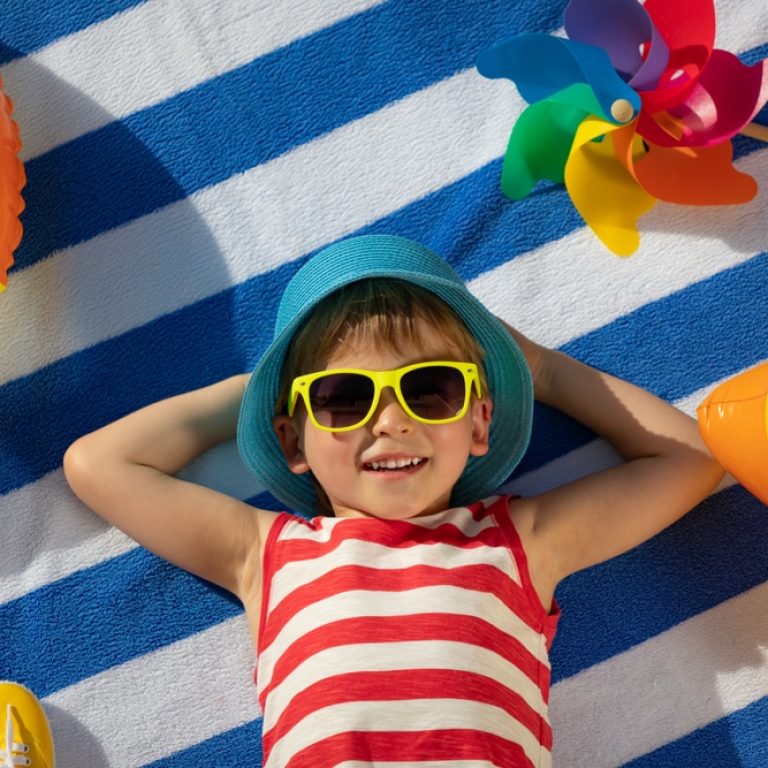 Happy,Child,Lying,On,Striped,Towel,Outdoor.,Top,View,Portrait
