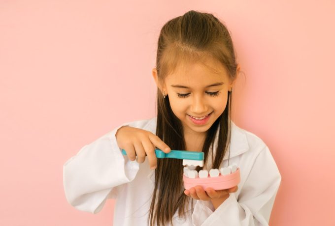 Girl,In,A,Dentist's,Medical,Gown,Shows,How,To,Properly