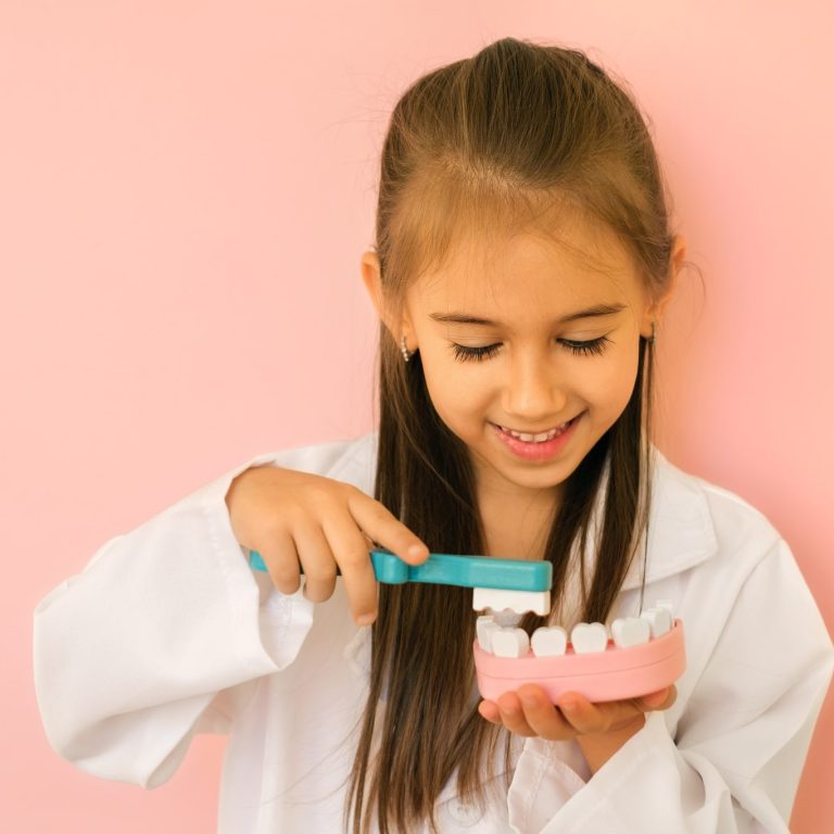Girl,In,A,Dentist's,Medical,Gown,Shows,How,To,Properly