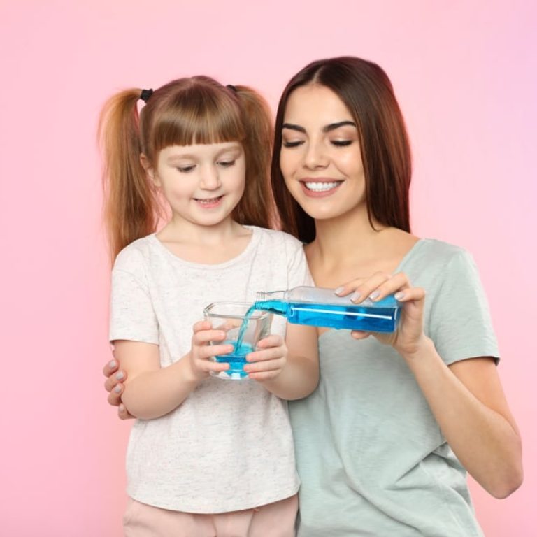 Little,Girl,And,Her,Mother,With,Mouthwash,On,Color,Background.