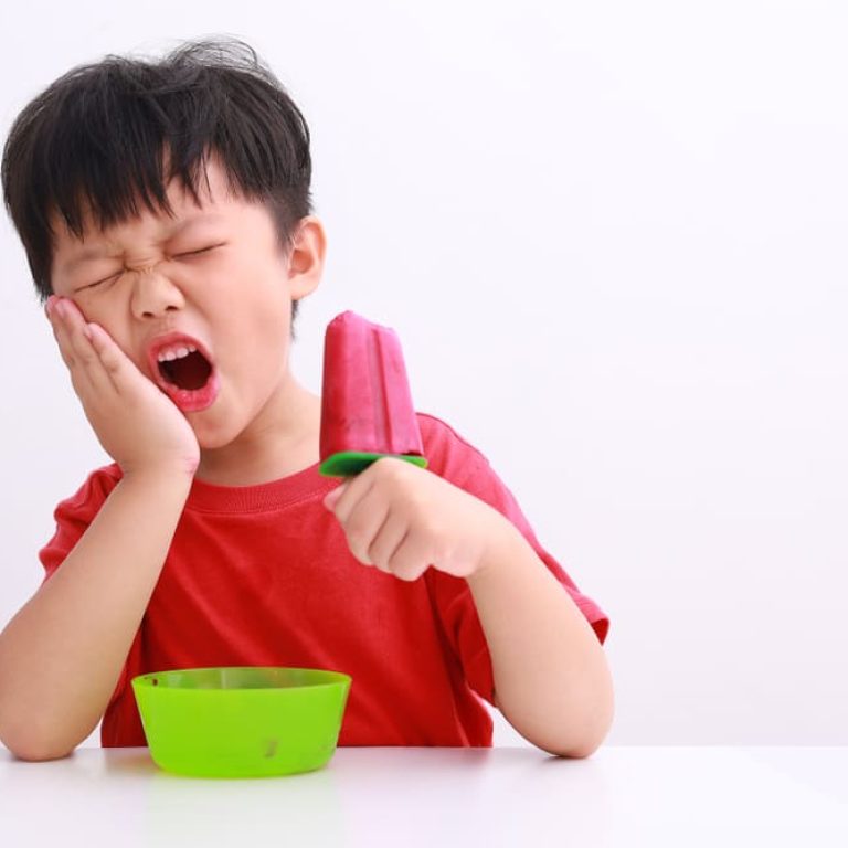 Little,Asian,Boy,Suffering,From,Toothache,While,Eating,Ice,Pop